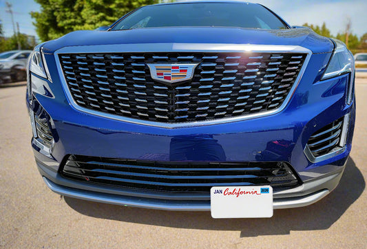 Blue Cadillac SUV with a California license plate in a parking lot